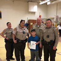 photo of boy 2 standing with deputies