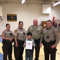 photo of boy standing with deputies