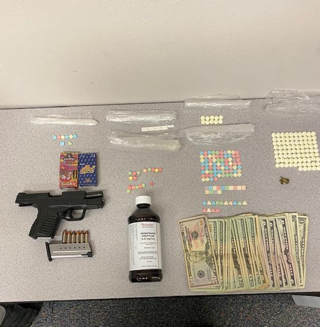 photo of drugs money and gun on table