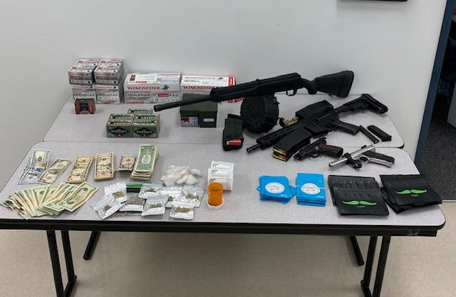 photo of drugs, money and firearms on table