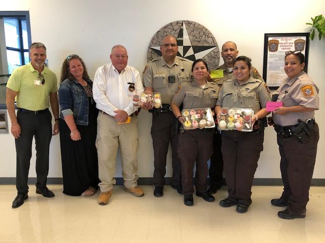 photo of sheriff and other deputies receiving cupcakes