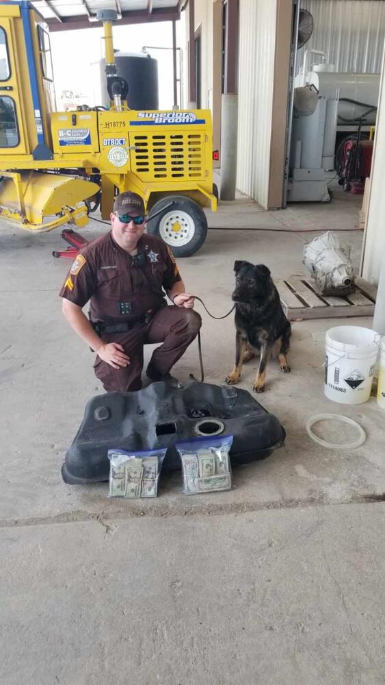 Photo of deputy, K-9, money and compartment