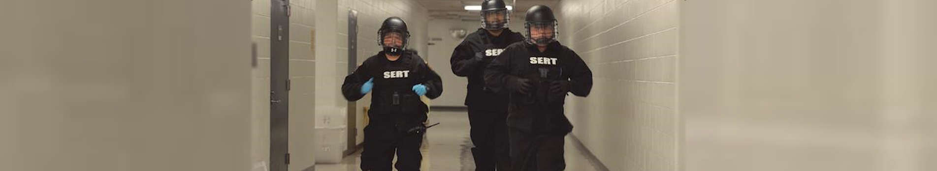 Sheriff deputies in riot gear in the halls of the jail.